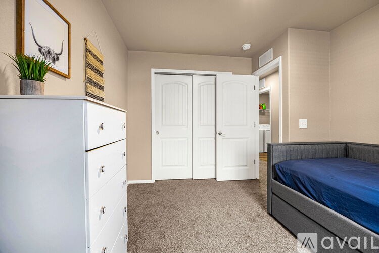 A bedroom with a bed, dresser, and a painting of a bull on the wall.