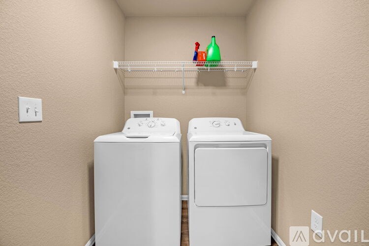 Two white front load washing machines in a laundry room.