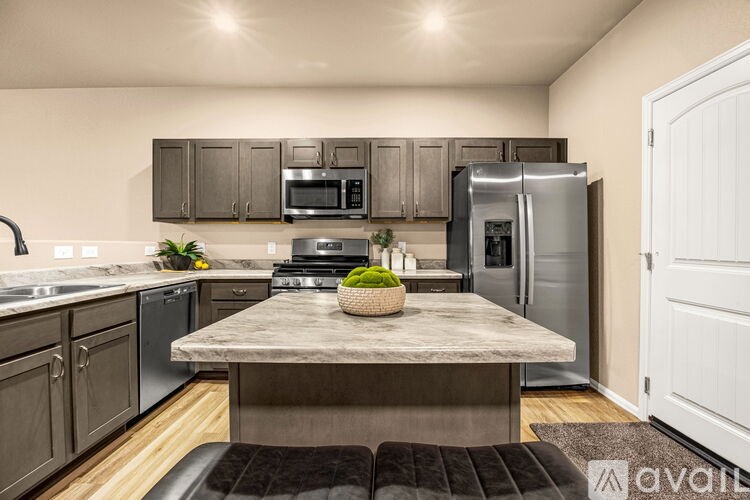 A kitchen with a marble table and stainless steel appliances.