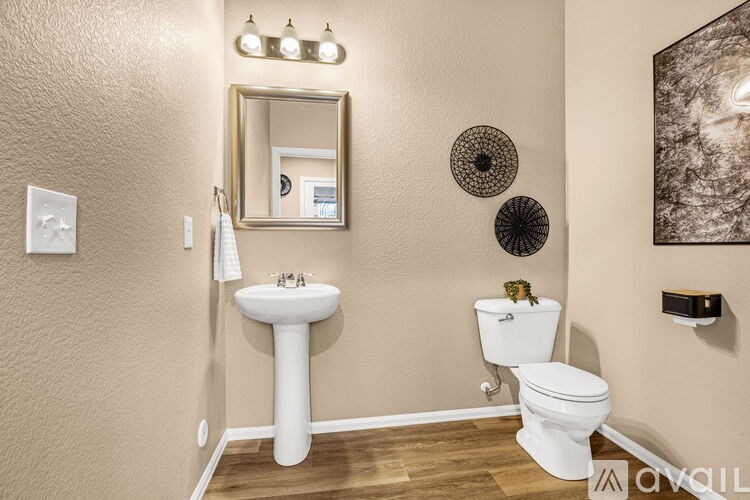 A bathroom with a sink, toilet and mirror.