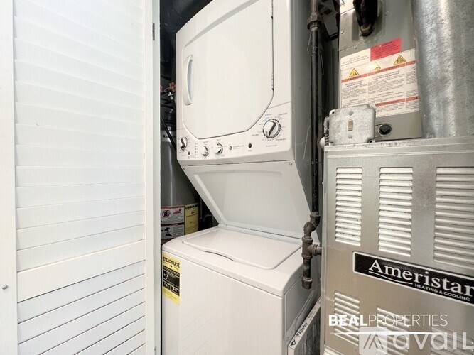 A white oven is installed in a wall next to a white fridge.
