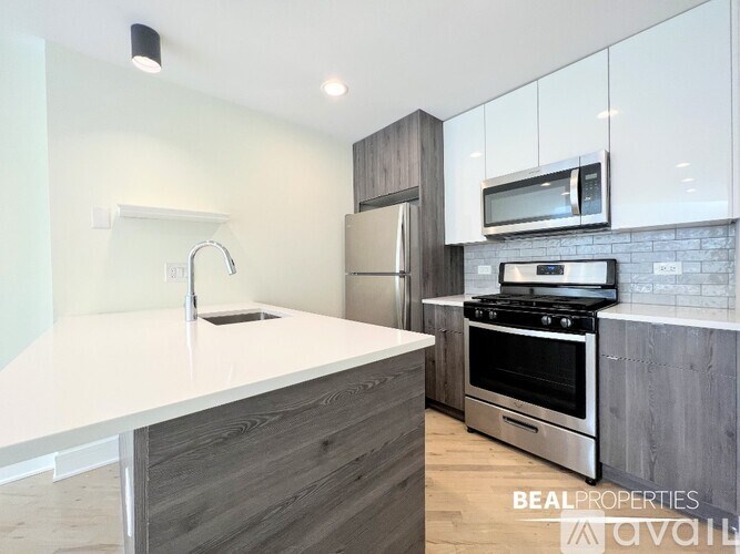 A modern kitchen with a white countertop and stainless steel appliances.