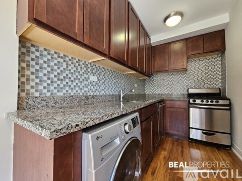 A kitchen with a washer and dryer built into the counter.