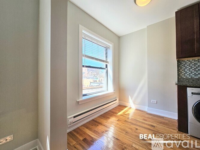 A room with a window and a washing machine.