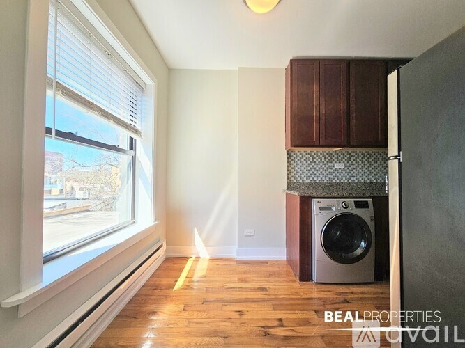 A BEALPROPERTIES sign is on a wall in a room with a washer and dryer.