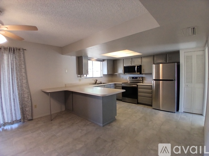 A kitchen with a stainless steel refrigerator and microwave.