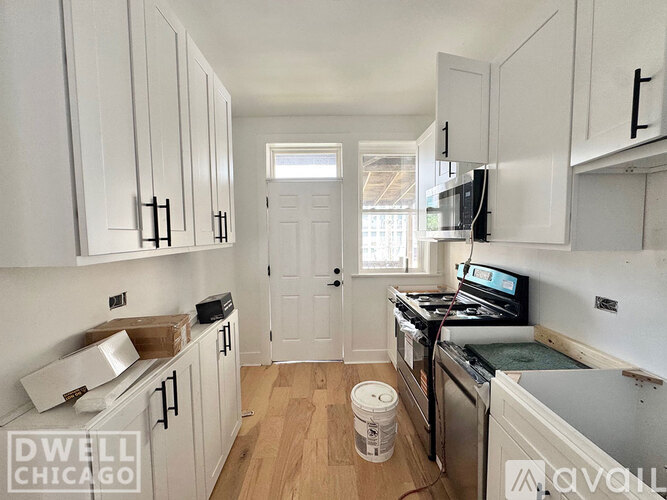 A kitchen with white cabinets and a black stove top oven.