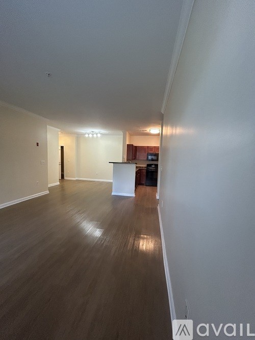 A long hallway with wooden floors and white walls.