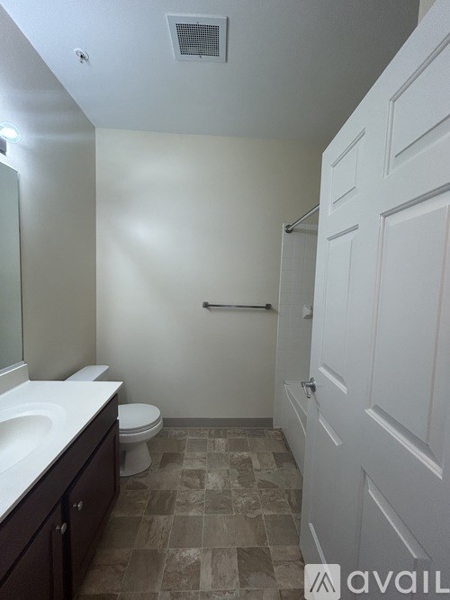 A bathroom with a toilet, sink, and a door.