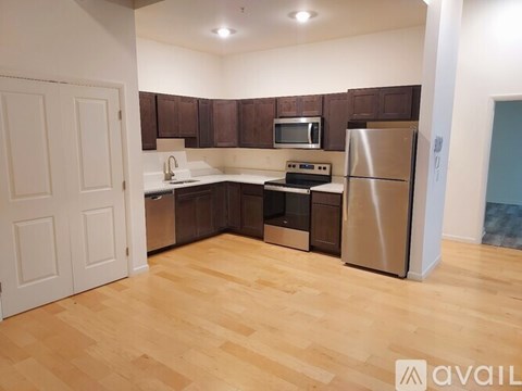 A kitchen with wooden floors and stainless steel appliances.