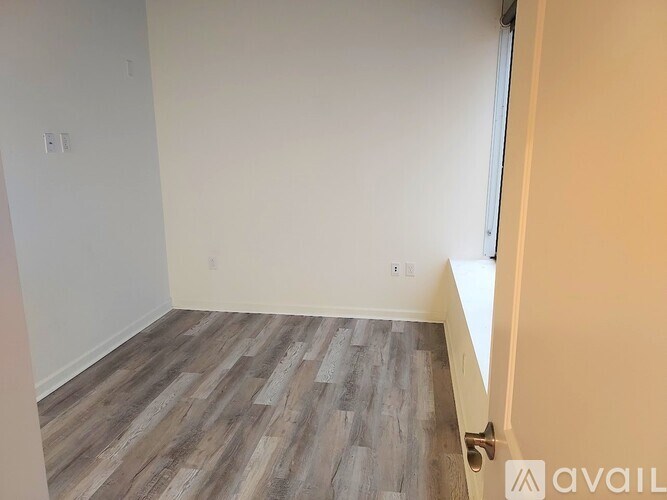 A room with wooden flooring and white walls.