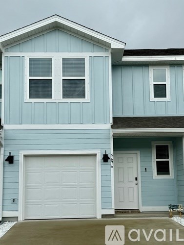 A blue house with a white garage door and a white door.