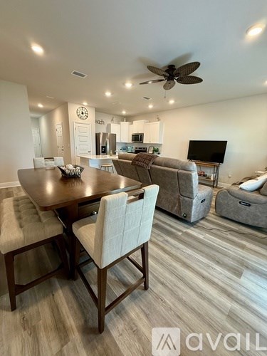 A modern dining room with a wooden table and chairs.