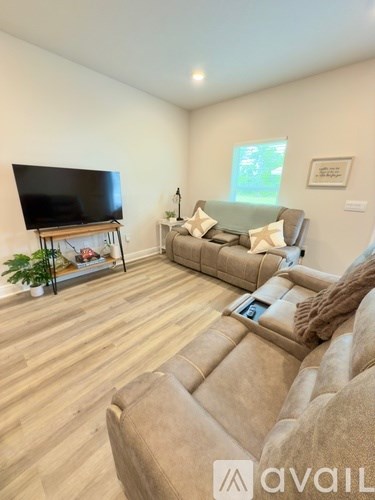 A living room with a large couch and a television on a stand.