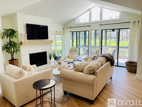A living room with a fireplace and a television on the wall.