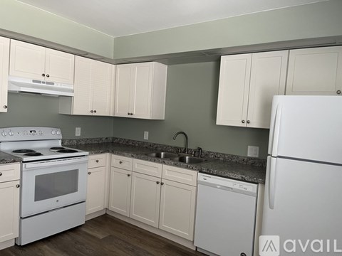 A kitchen with white appliances and cabinets.