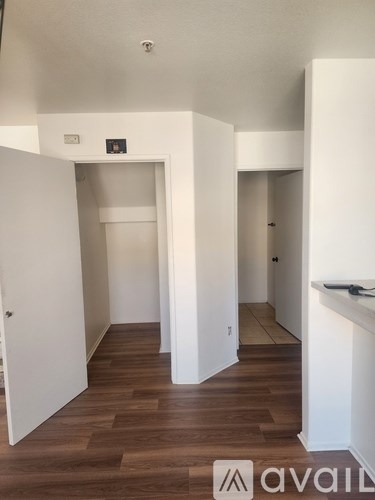 A hallway with wood flooring and white walls.