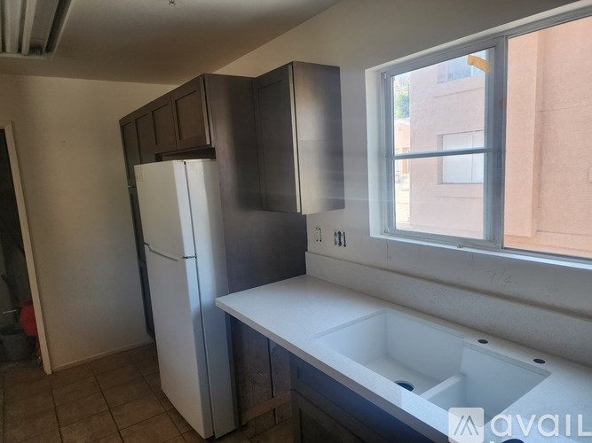 A kitchen with a white fridge and a white sink.