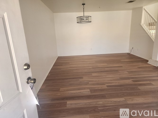 A room with wooden flooring and a white door.