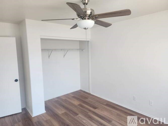 A room with a ceiling fan and a door.