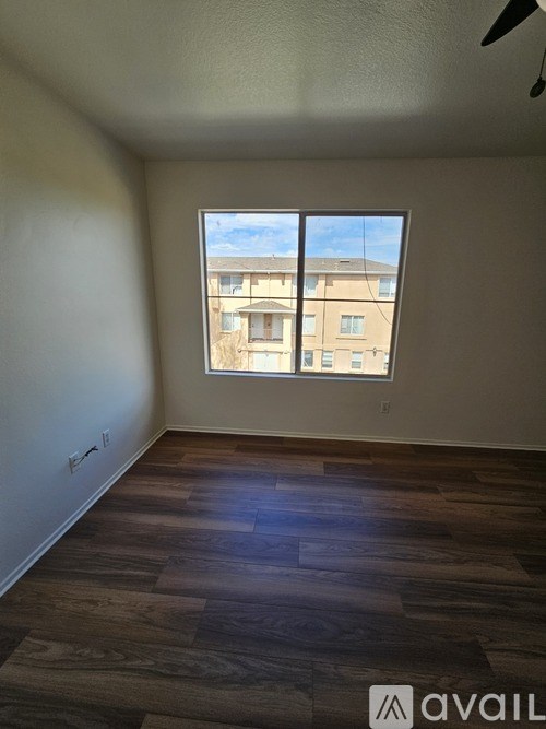 A room with a large window and wooden flooring.