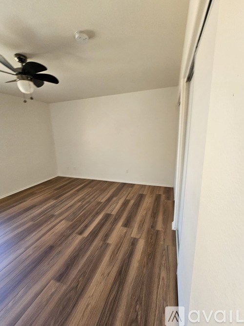 A room with wooden flooring and a ceiling fan.