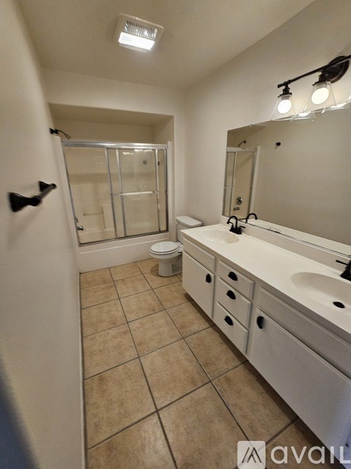 A bathroom with a toilet, sink, and mirror.