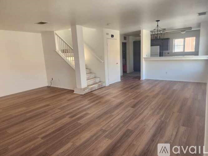 A room with wooden flooring and a staircase.