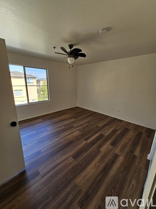 A room with wooden flooring and a ceiling fan.