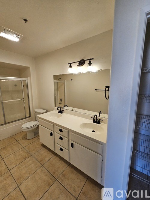 A bathroom with a toilet, sink, and mirror.