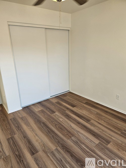 A room with a sliding door and wood flooring.