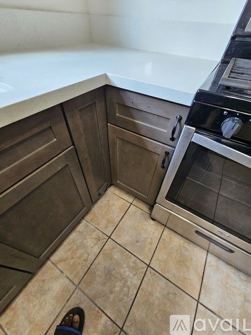A kitchen with a tile floor and a stainless steel oven.