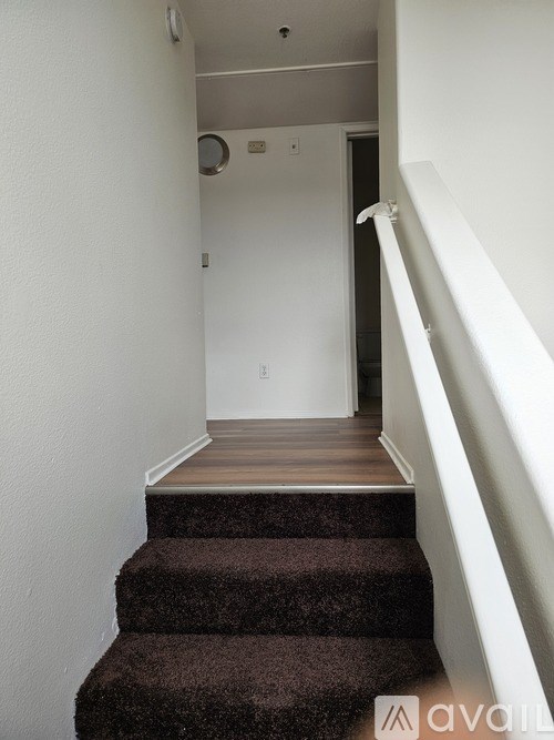 A staircase with a carpeted runner and white walls.