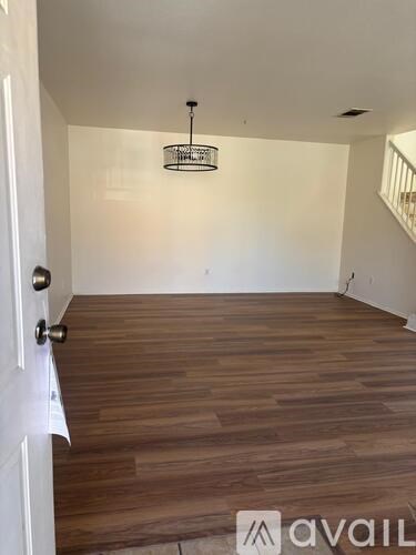 A room with wooden flooring and a chandelier.