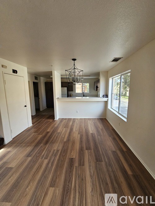 A room with wooden flooring and a chandelier.