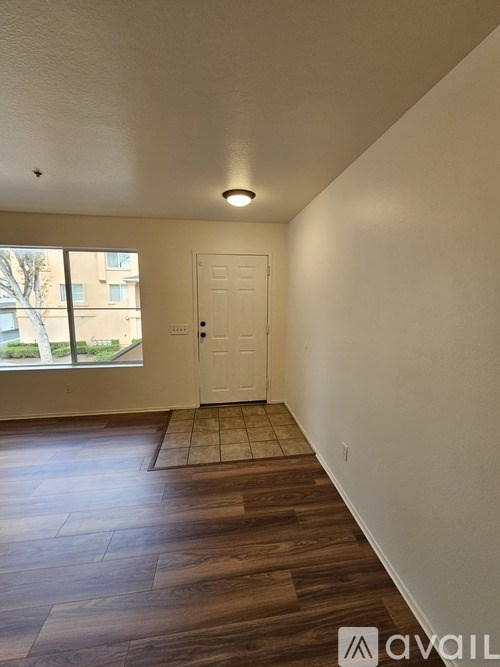 A room with a white door and a window with a view of a building outside.