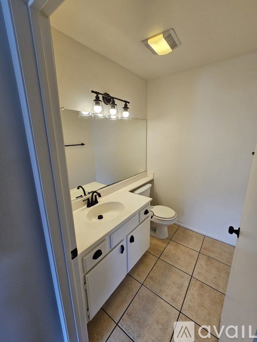 A bathroom with a sink, mirror, and toilet.