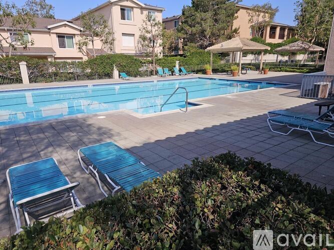 A pool with blue loungers and a white umbrella.