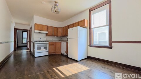 A kitchen with wooden cabinets and white appliances is available for rent.