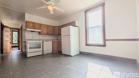 A kitchen with a refrigerator, oven, and sink.