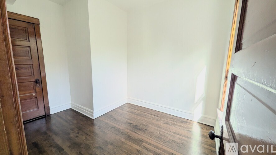 A room with a wooden door and a wooden floor.