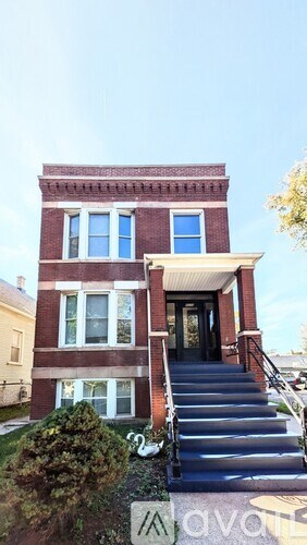 A red brick house with a blue sky in the background.