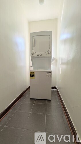 A white arcade machine sits in a hallway.