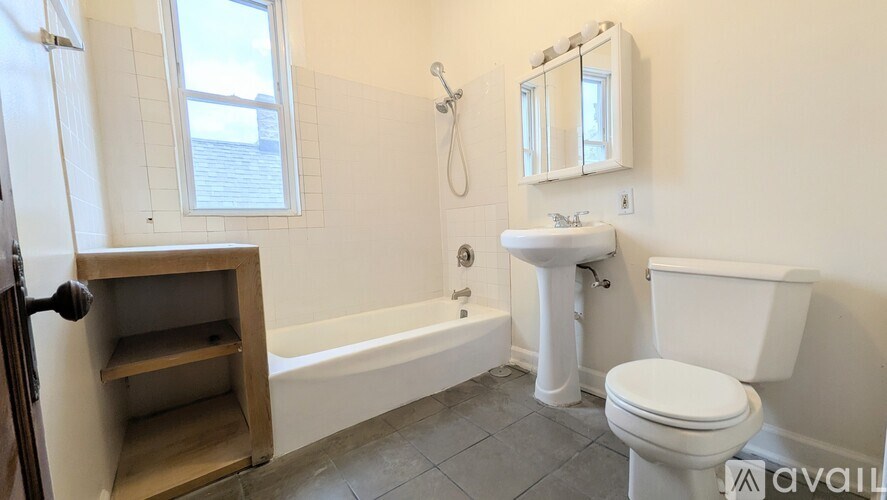 A white toilet sits next to a white sink in a bathroom.