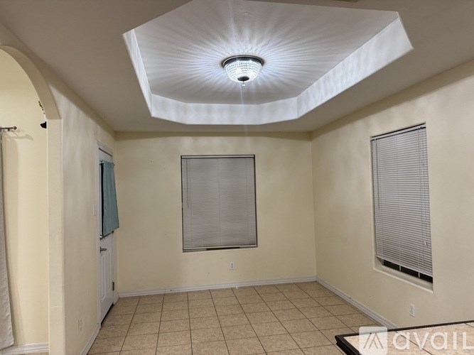 A room with a white ceiling and a window with blinds.