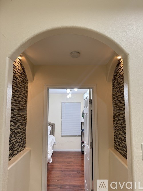 A hallway with a brick wall and a white door.