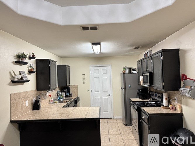 A kitchen with black appliances and a white door.