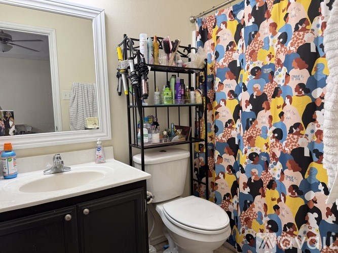 A bathroom with a shower curtain featuring a pattern of people.