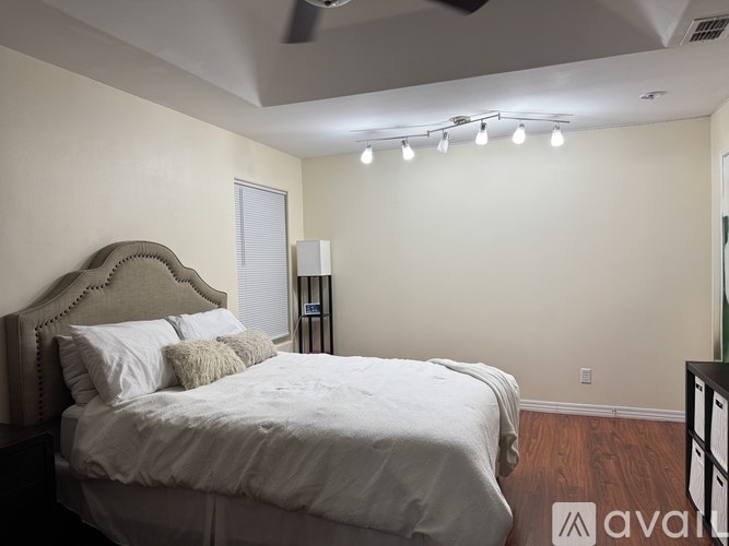 A bedroom with a large bed and a ceiling fan.