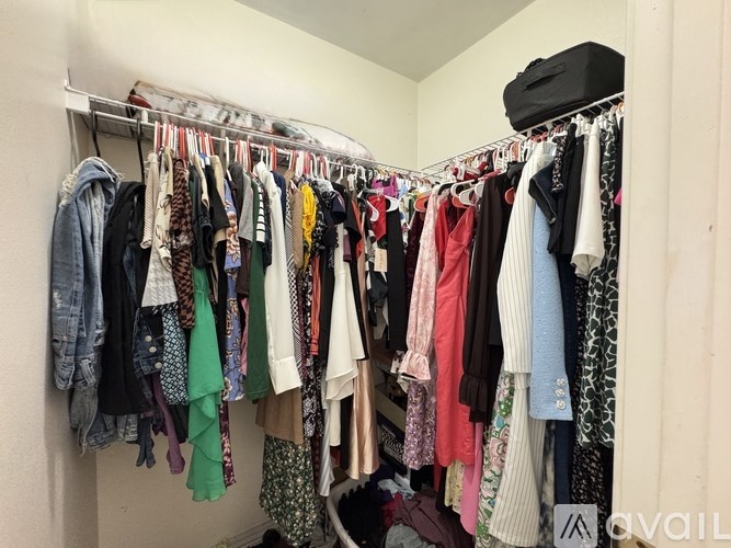 A closet full of clothes hanging on a rail.